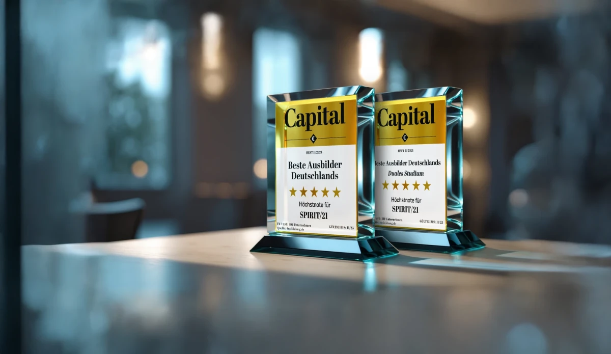 Zwei Auszeichnungen aus Glas stehen auf einem B&uuml;rotisch. Die Auszeichnungen sind f&uuml;r die Besten Ausbilder und das beste Duale Studium ausgezeichnet von Capital | SPIRIT/21