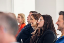 Im Fokus sind zwei Frauen, die interessiert bei einem Vortrag zuh&ouml;ren. Im Hintergrund sind weitere Personen | SPIRIT/21