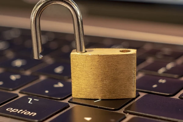 Ein offenes Vorh&auml;ngeschloss steht auf einer Apple Mac Tastatur eines Macbooks | SPIRIT/21