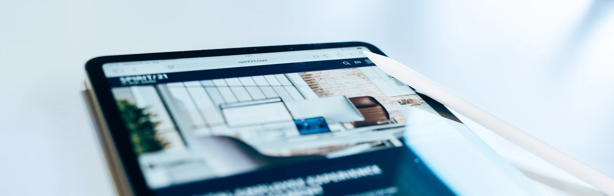 Tablet mit ge&ouml;ffneter Unternehmenswebsite spirit21.com, dargestellt in einem modernen digitalen Arbeitsplatz mit Stylus-Stift. | SPIRIT/21